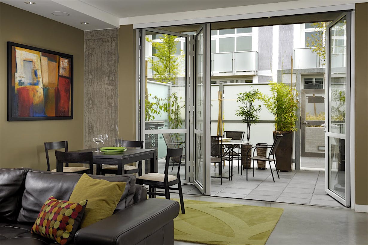 Retractable patio doors as slim small‑opening glass doors connect indoor and outdoor space with modern elegance