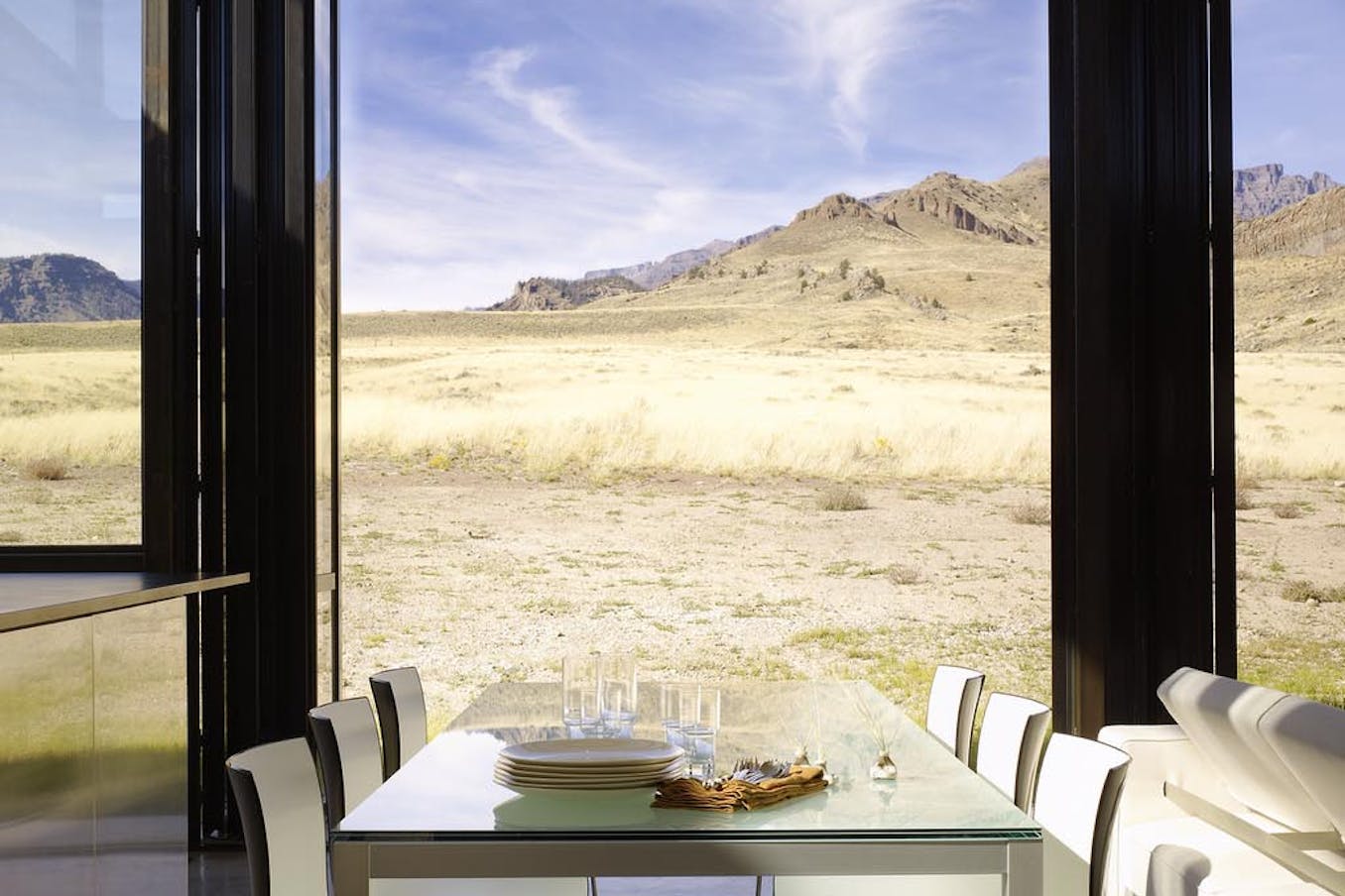 A table with plates and glasses on it in front of a desert landscape - SL70 folding