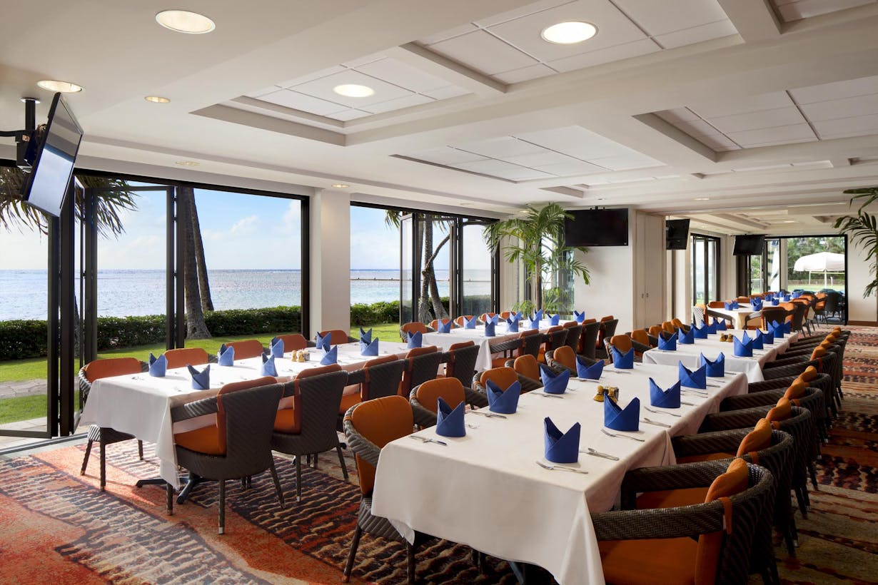 Country club dining area with large folding glass walls and a view of the ocean