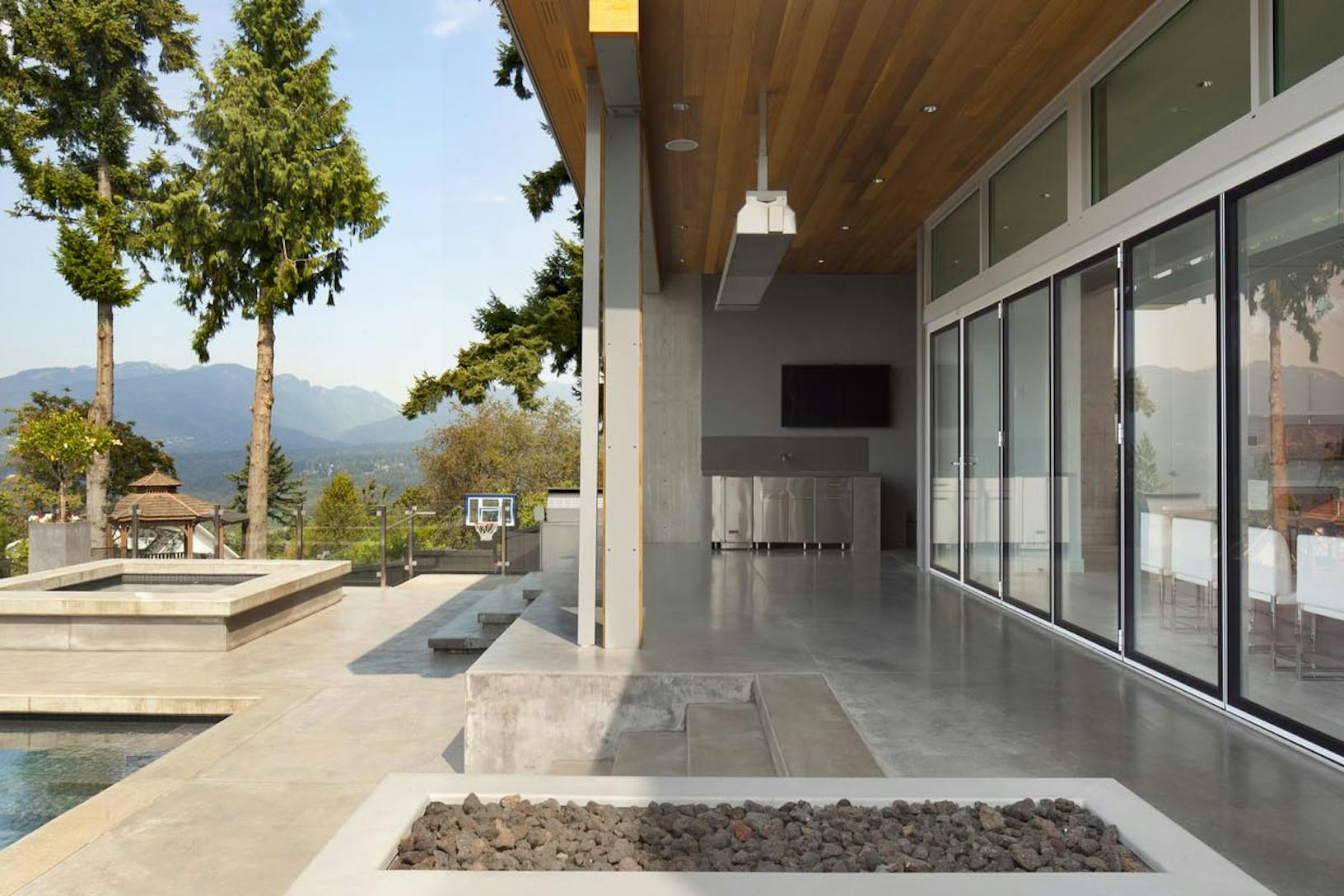Large pool house with folding desk doors with view of the mountains
