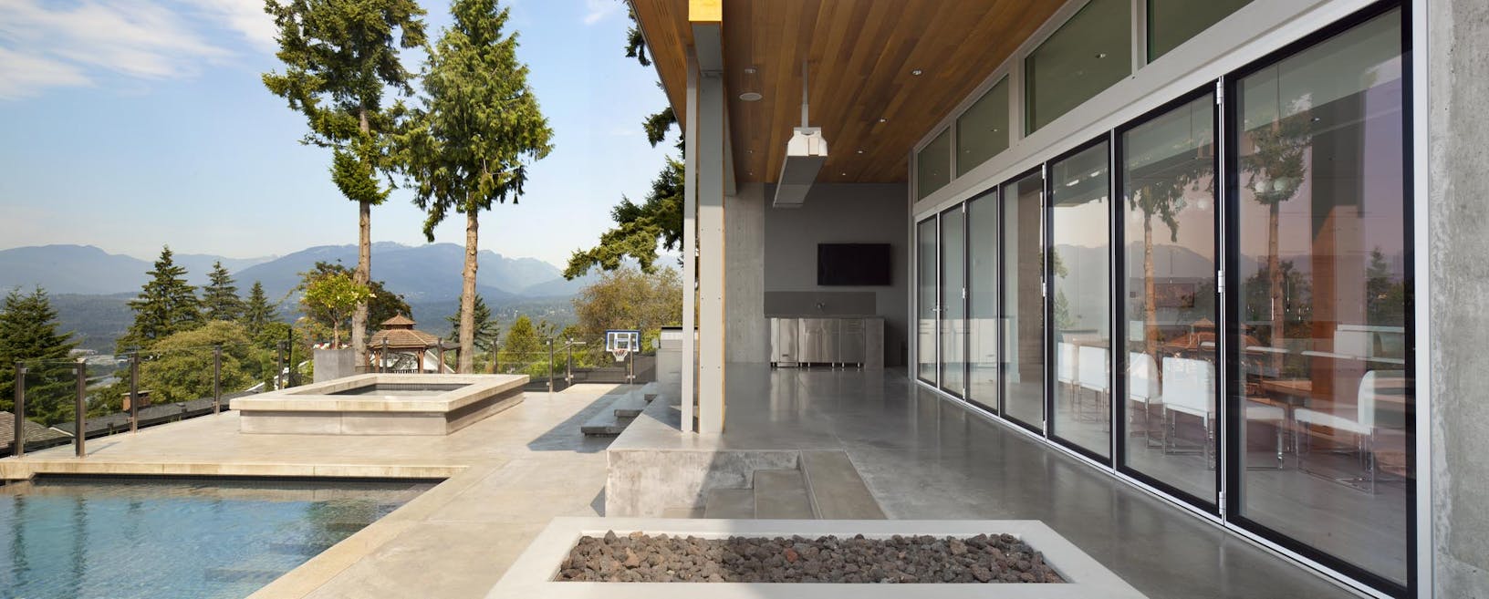 Large pool house with folding desk doors with view of the mountains