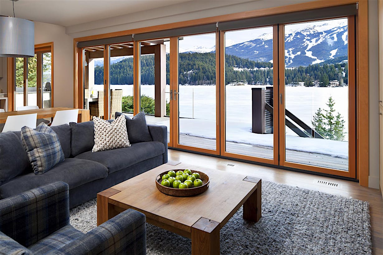 Retractable patio doors at a Whistler, BC home offer energy efficiency and seamless indoor-outdoor living by the lake