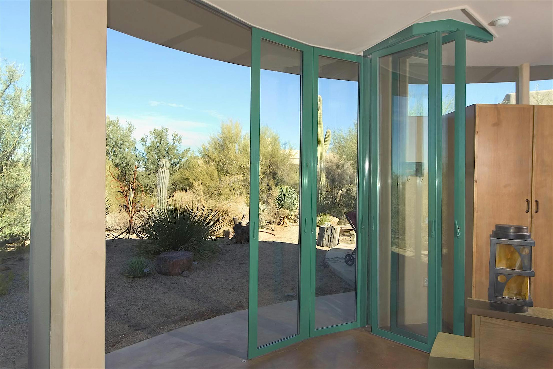Curved sliding patio doors in Arizona nearly stacked opening to desert views and seamless indoor‑outdoor flow