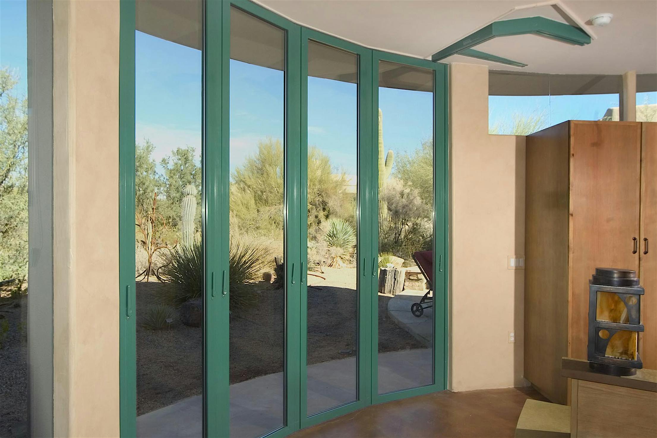 Curved sliding patio doors in Arizona open to stunning desert views, blending indoor spaces with the surrounding landscape