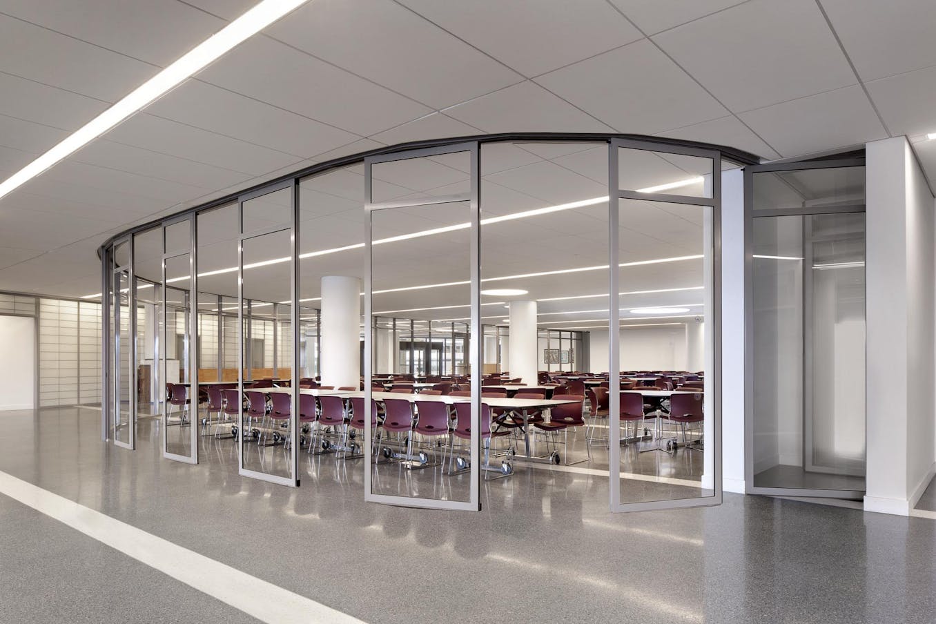 commercial collaborative learning space in school design - segmented curved sliding walls opening exterior 