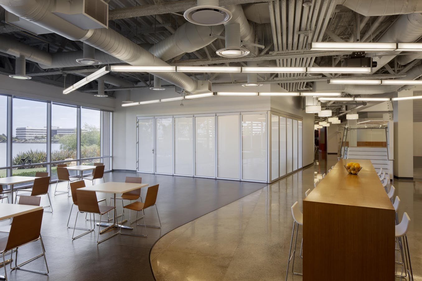 Modern office with white glazing glass walls dividers tables and chairs and a large window