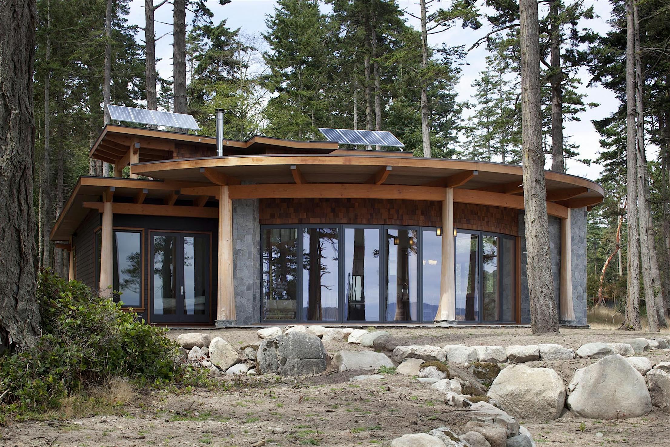 HSW60 cabin in the woods with segmented curved glass walls design
