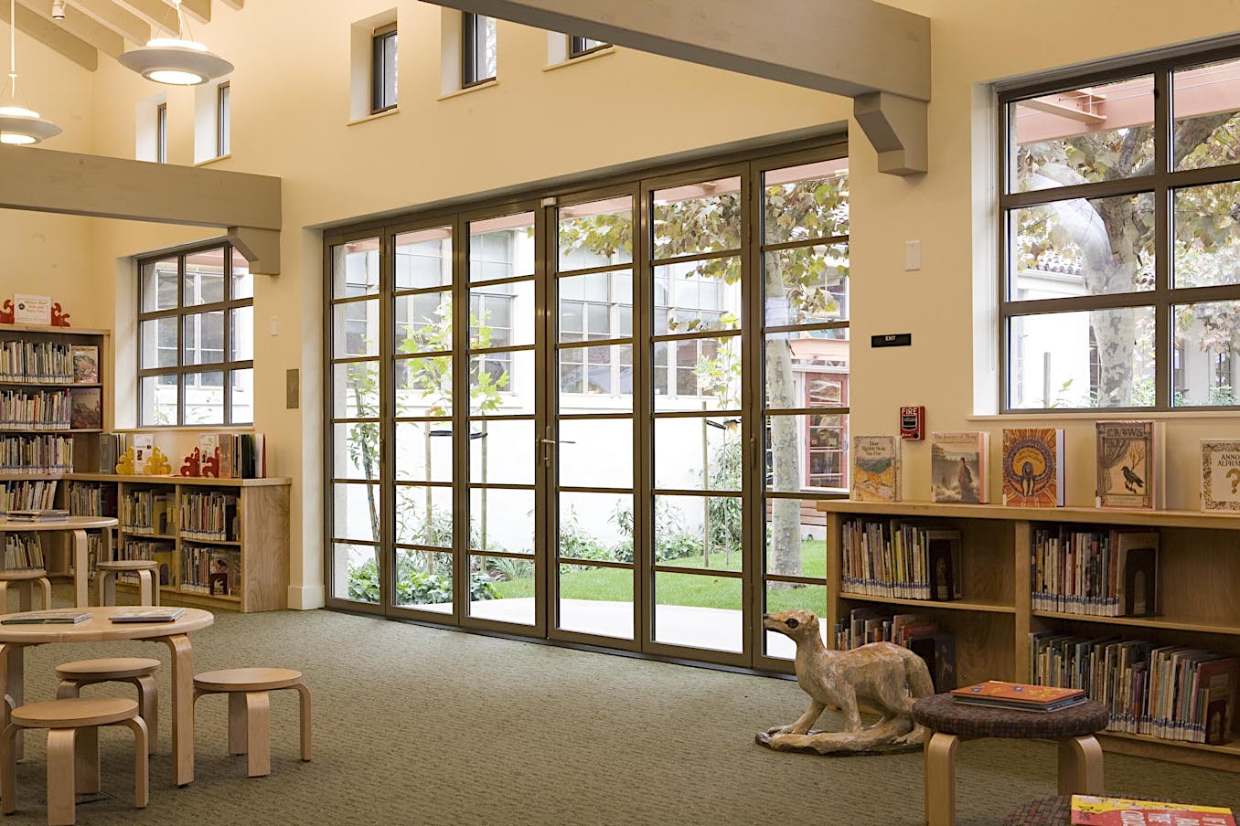 A room with bookshelves and divided lite folding glass walls