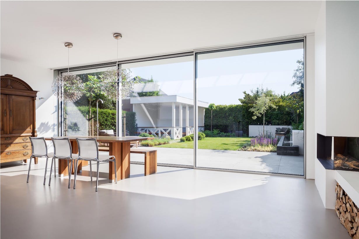 Modern living room with floor to ceiling minimal framed sliding glass walls