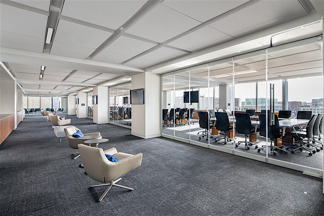 Modern office with a conference room separated by closed sliding glass walls featuring a single-track sliding system.
