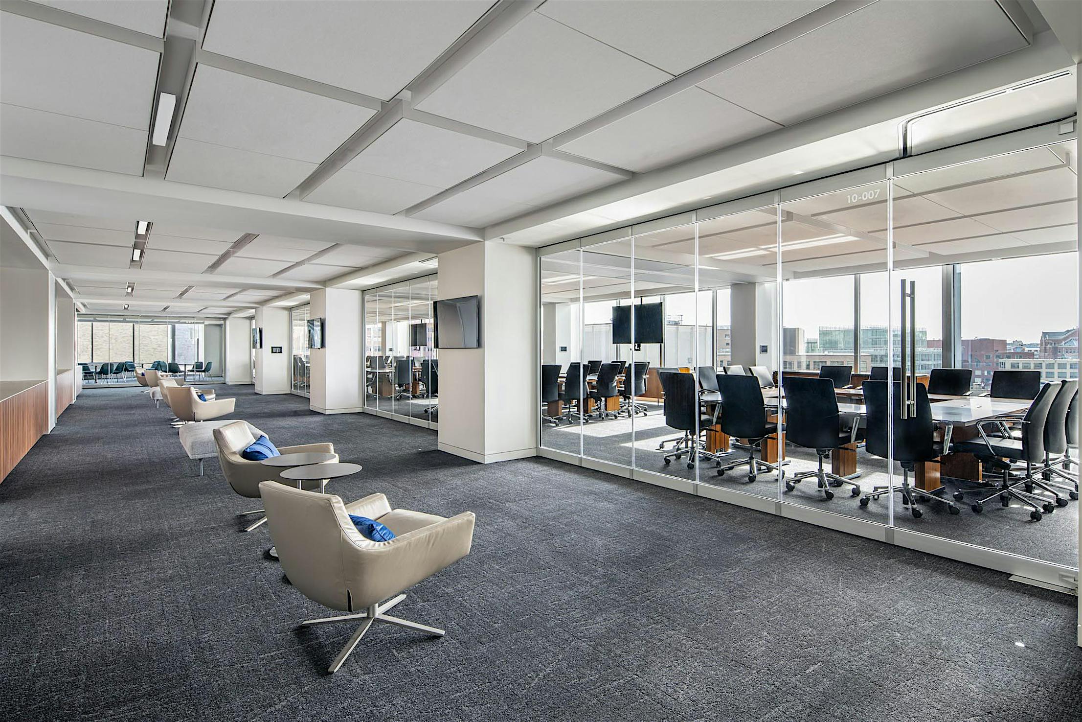 Modern office with a conference room separated by closed sliding glass walls featuring a single-track sliding system.