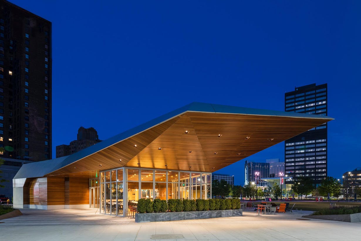 A modern restaurant building with a wooden roof and enhanced forced entry protection in the middle of a city