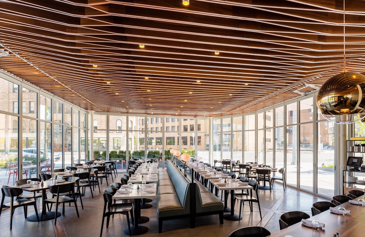 The interior of a restaurant with wooden ceilings and folding glass walls providing forced entry protection