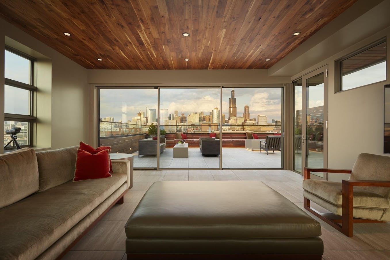 A living room with minimal glass walls and a view of the city