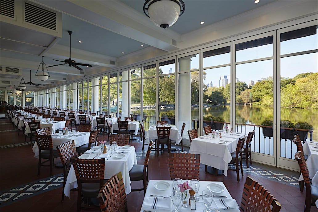 The Loeb Boathouse Central Park, New York, NY | Restaurant with floor-to-ceiling sliding glass doors overlooking a scenic lake.