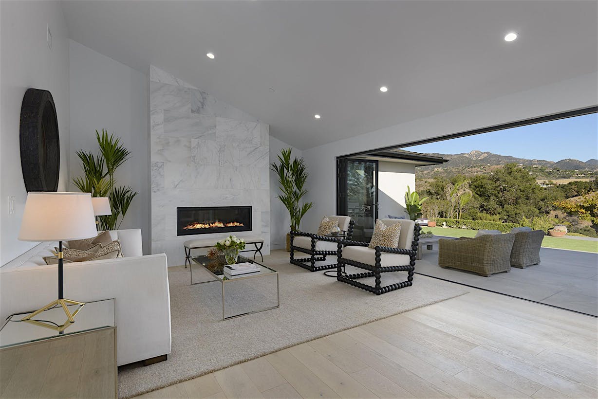 White Large Living Room with a Fireplace and Folding Patio Doors  - Glass Walls