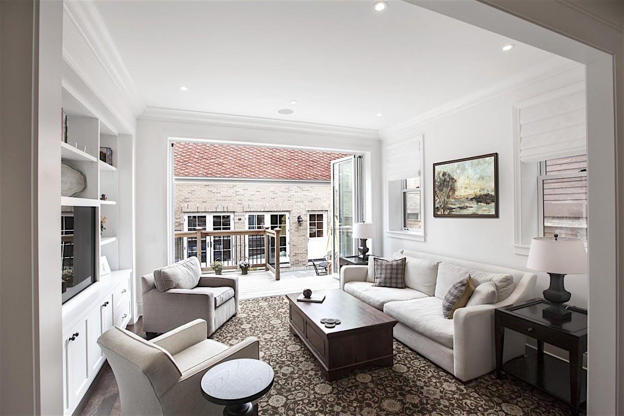 Folding exterior doors with small opening enhance indoor-outdoor living at Chicago Graystone multifamily residence in Chicago, IL.