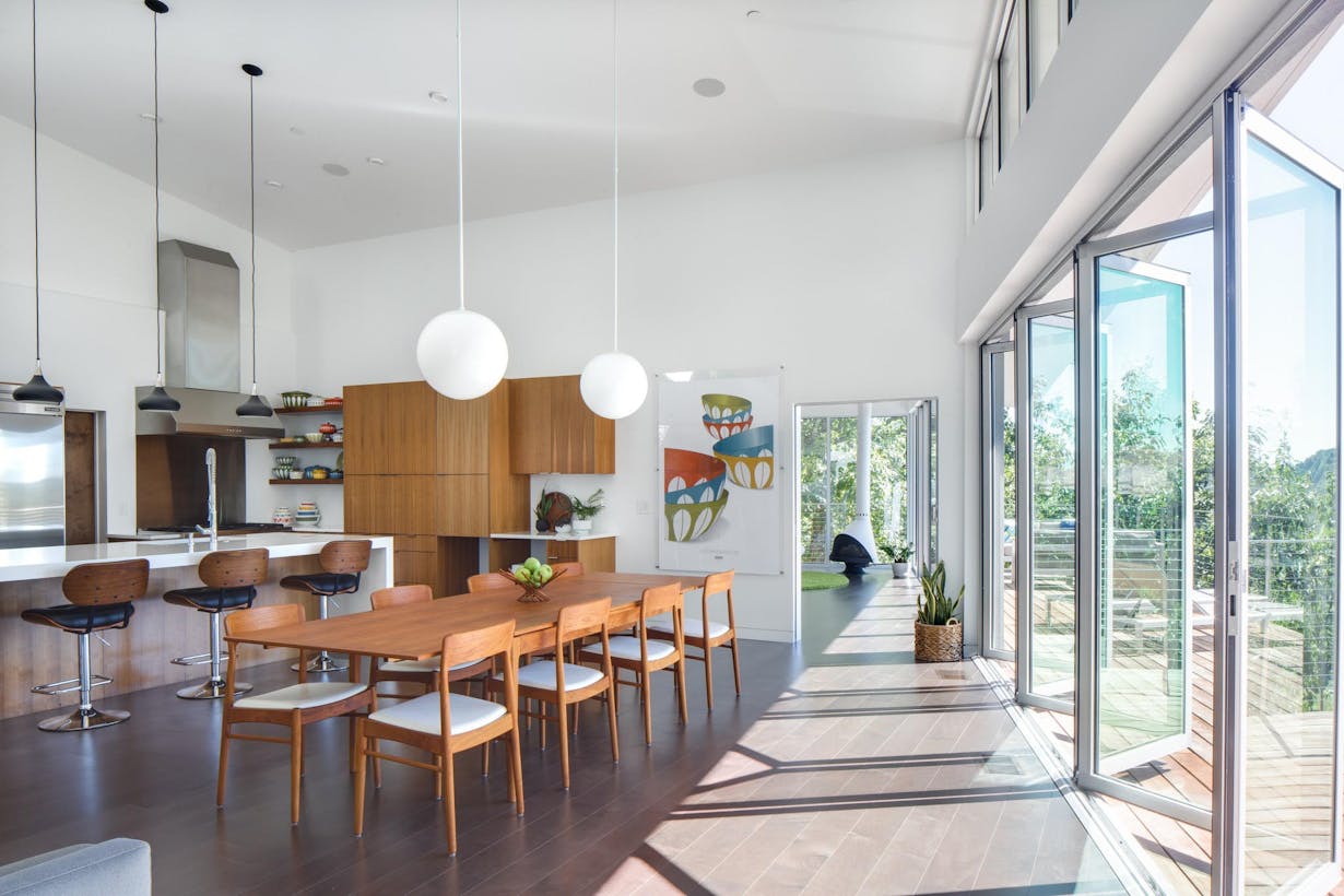A modern dining room and kitchen with glass doors
