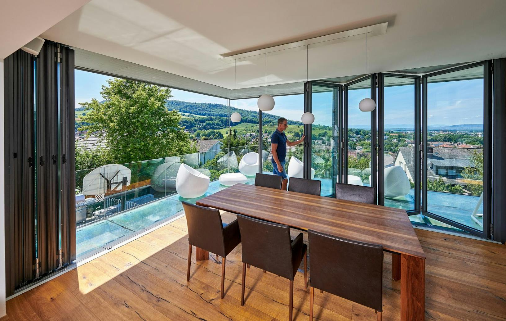 Dining room with open corner folding glass walls and view of the mountains