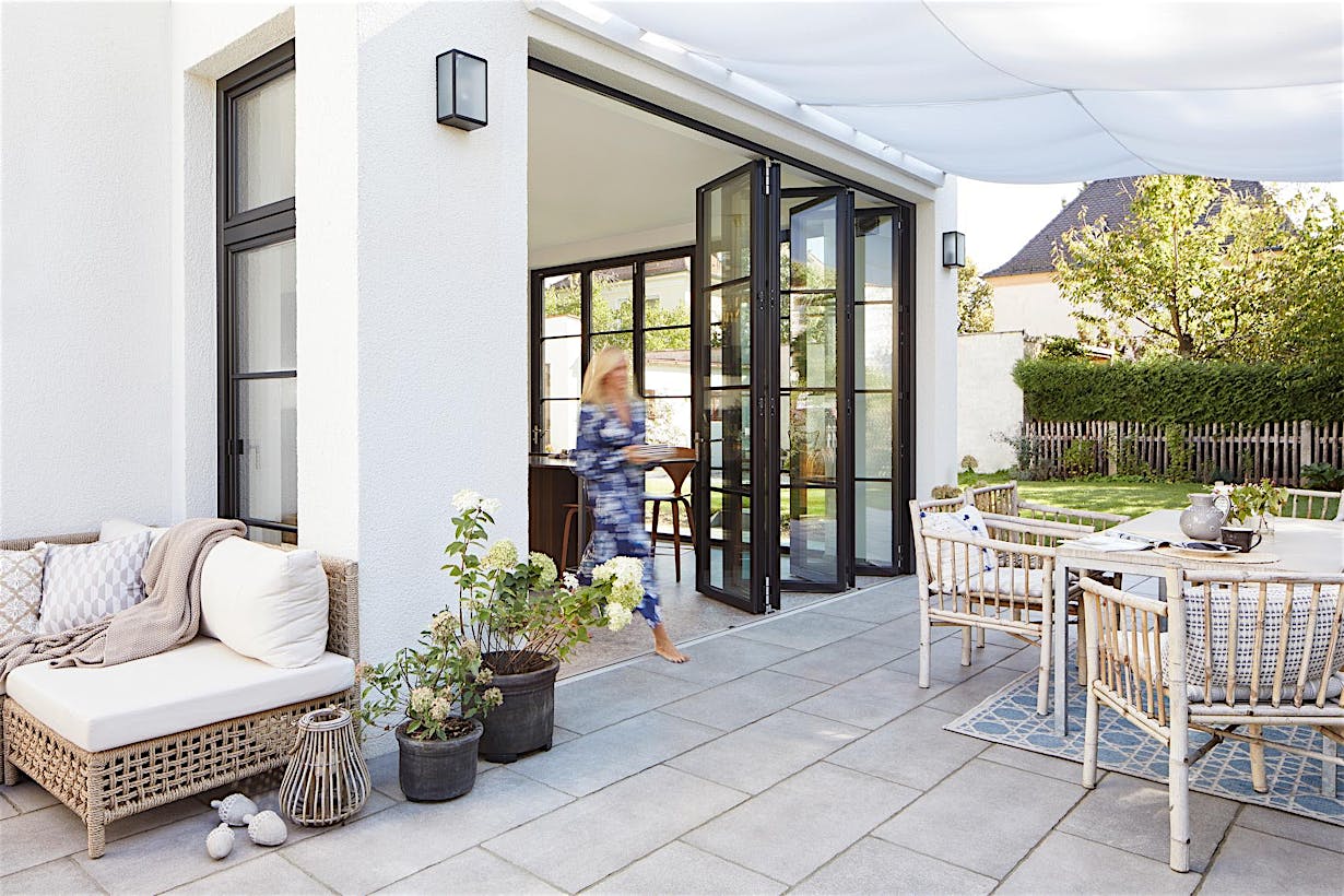 Folding glass patio doors seamlessly integrate indoor and outdoor space for modern, open-concept living