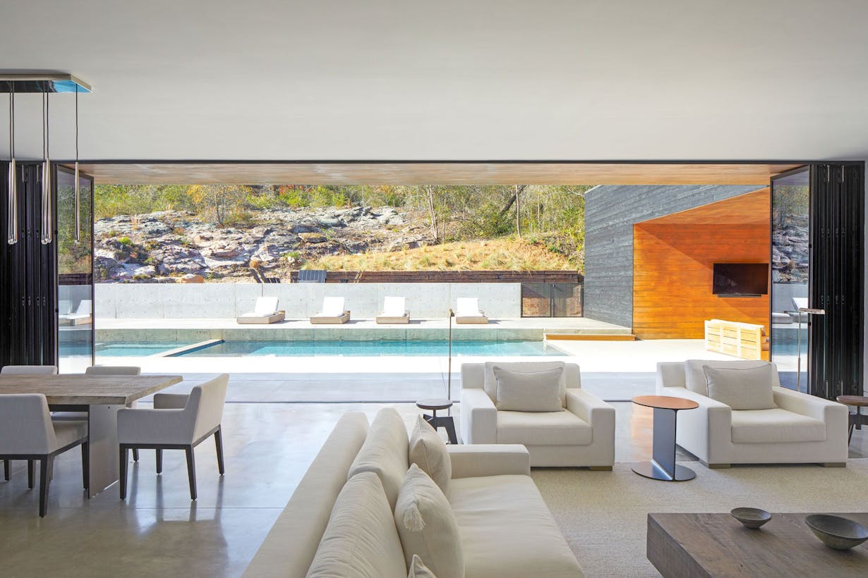 Large Open Living Room with Folding Glass Walls leading to Outdoor Pool - Folding