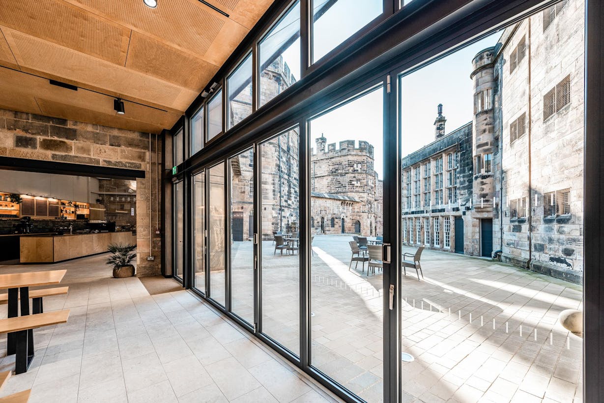 A courtyard with a large folding glass door, perfect for commercial spaces or restaurants