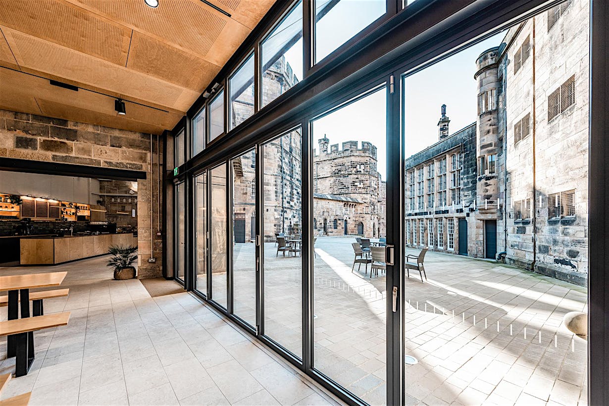 A courtyard with a large folding glass door, perfect for commercial spaces or restaurants