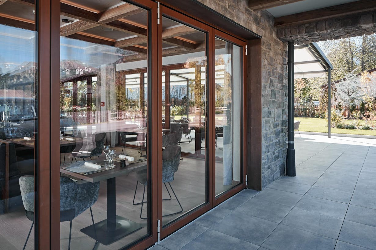 Glass wood framed patio doors with a view of a stone patio