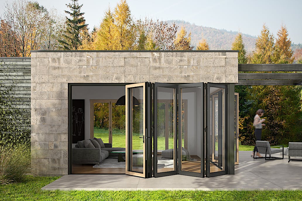 A modern ADU with open folding glass doors leading from a living room to a patio