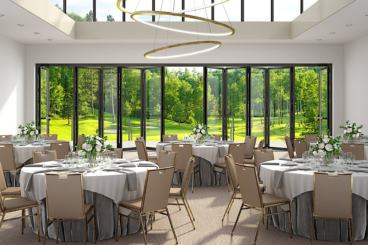A banquet room with a view of a golf course, featuring commercial glass walls - partially open doors
