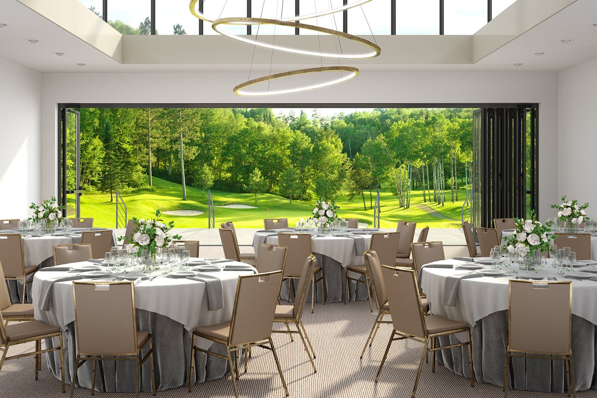 A banquet room with a view of a golf course, featuring commercial glass walls - doors stacked to the right