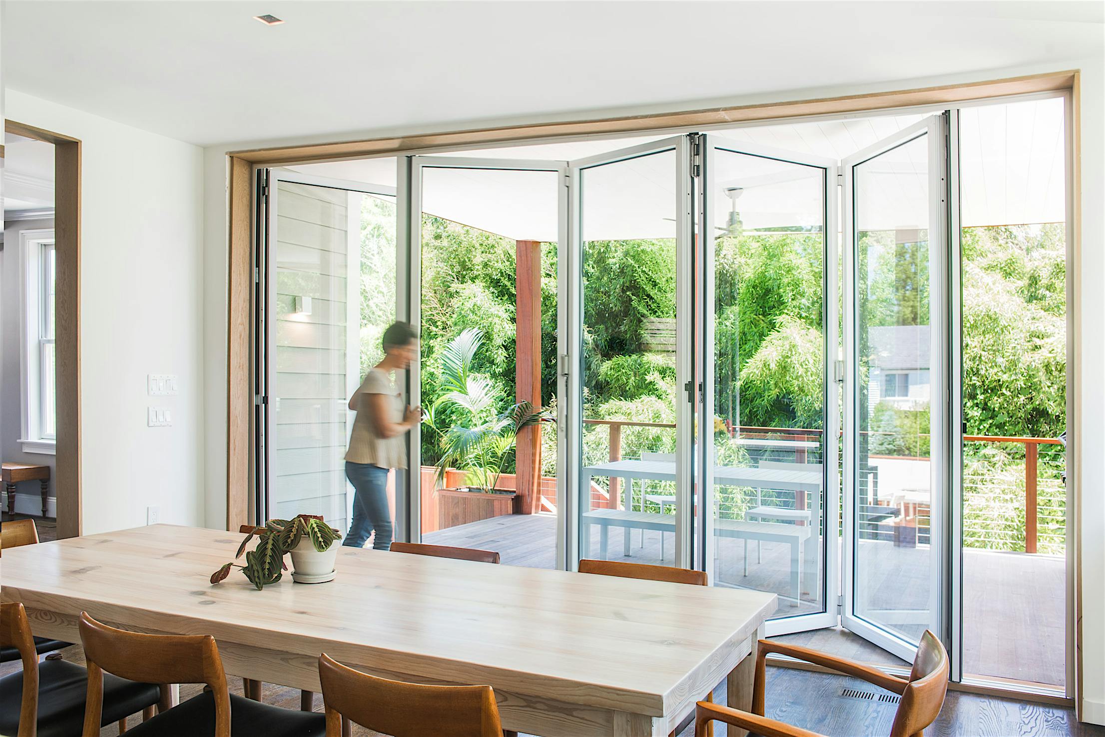 Accordion glass patio doors in Bethesda, MD integrate indoor and outdoor space for seamless, modern living environments