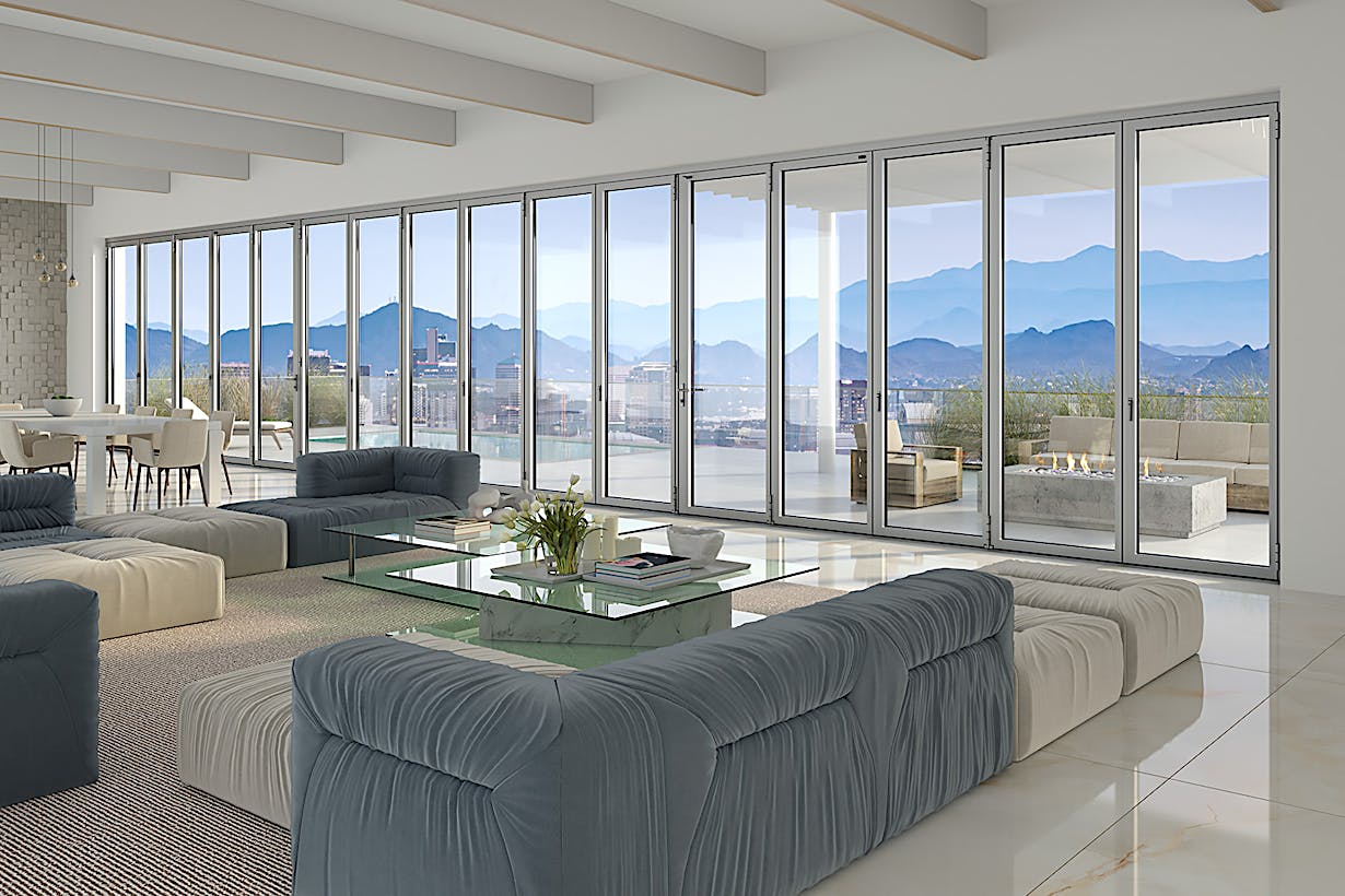 A living room with folding glass walls offering a breathtaking view of the mountains