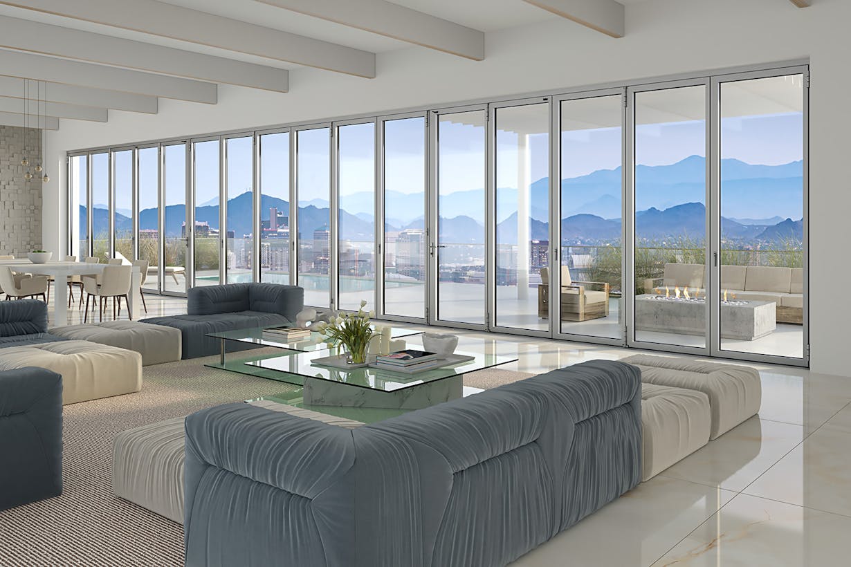 A living room with folding glass walls offering a breathtaking view of the mountains