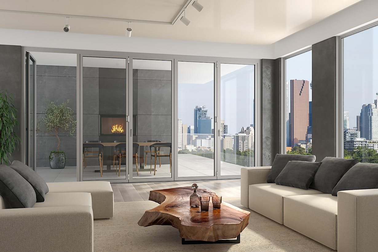 A living room with high rise glass walls overlooking a city