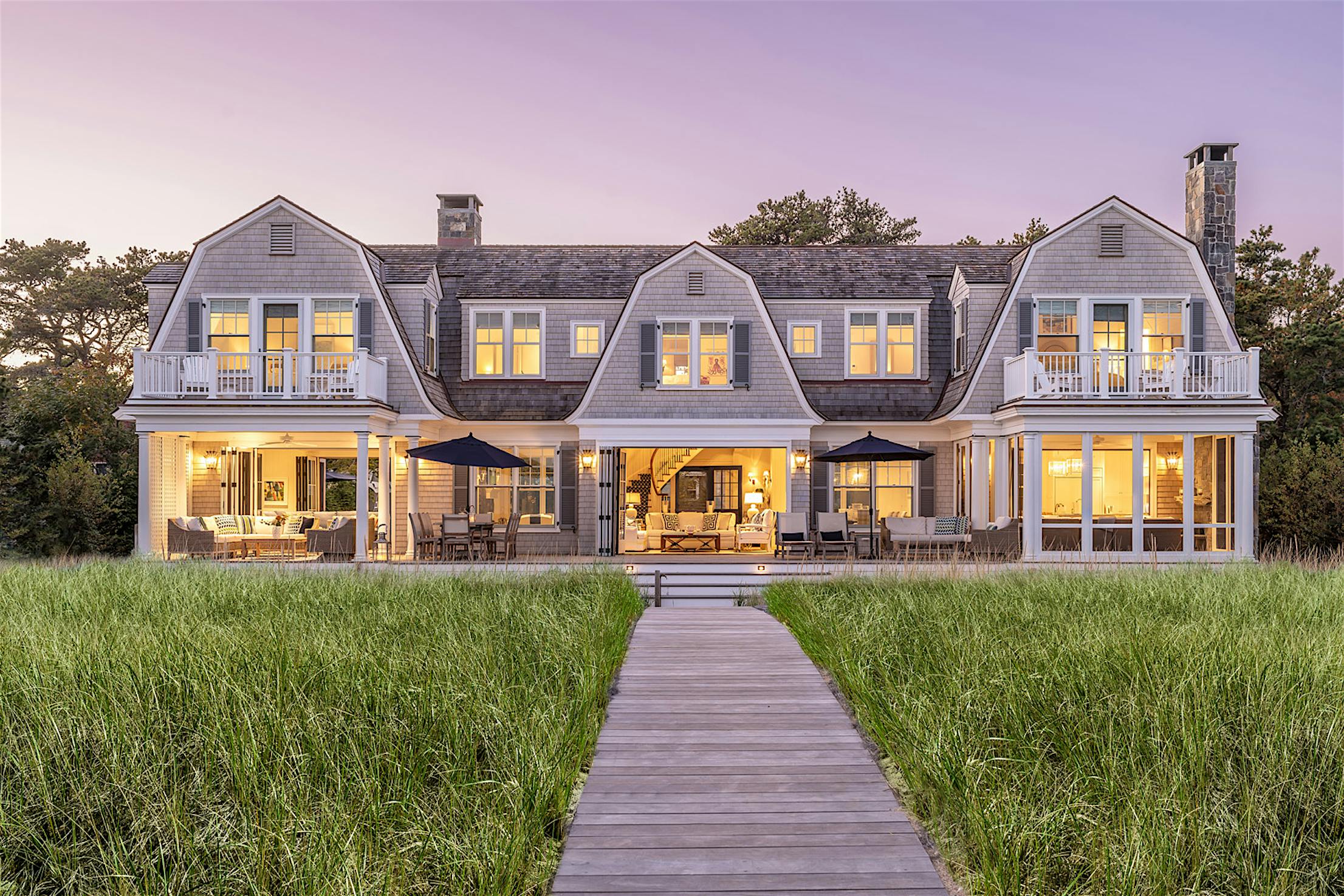 Two story large residential exterior with a walkway leading to large opening aluminum clad folding glass walls