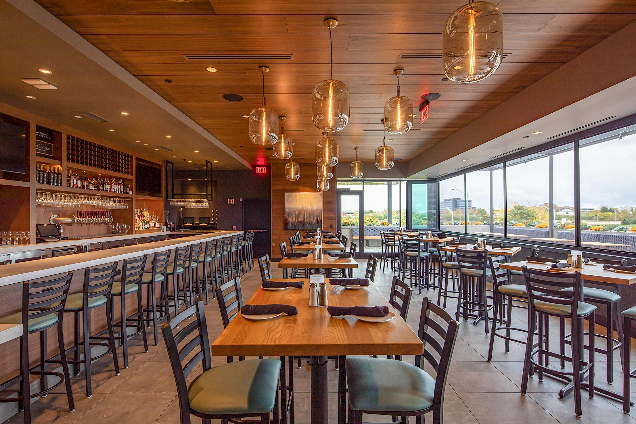 Restaurant interior with folding window overlooking an outdoor dining area