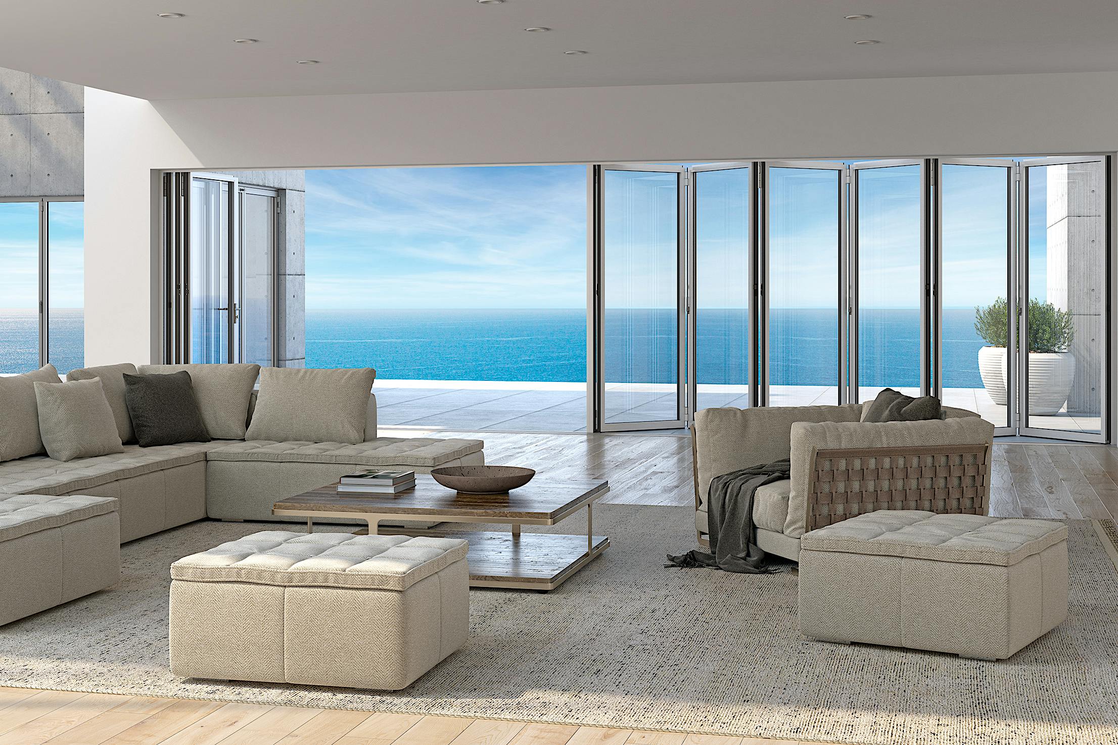 A modern living room features a large folding glass doors opening to a deck with ocean view