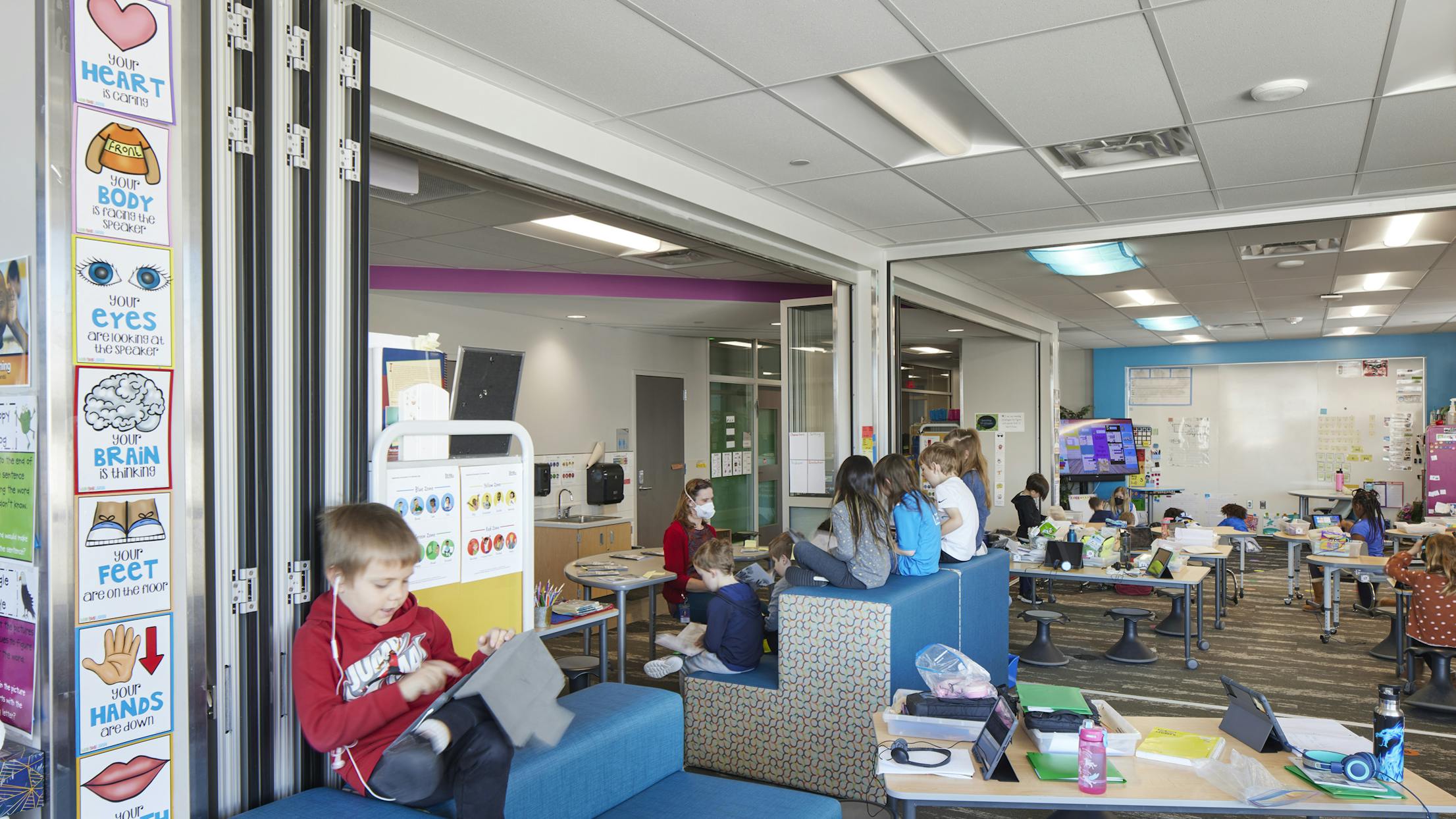 Learning space - young kid seating next to folding glass doors