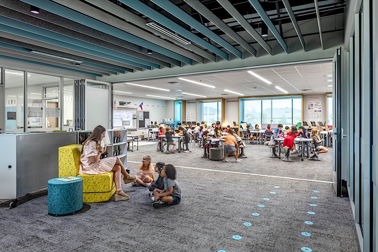 Modern classroom with acoustical commercial folding glass doors and bright lighting, creating an ideal education environment.