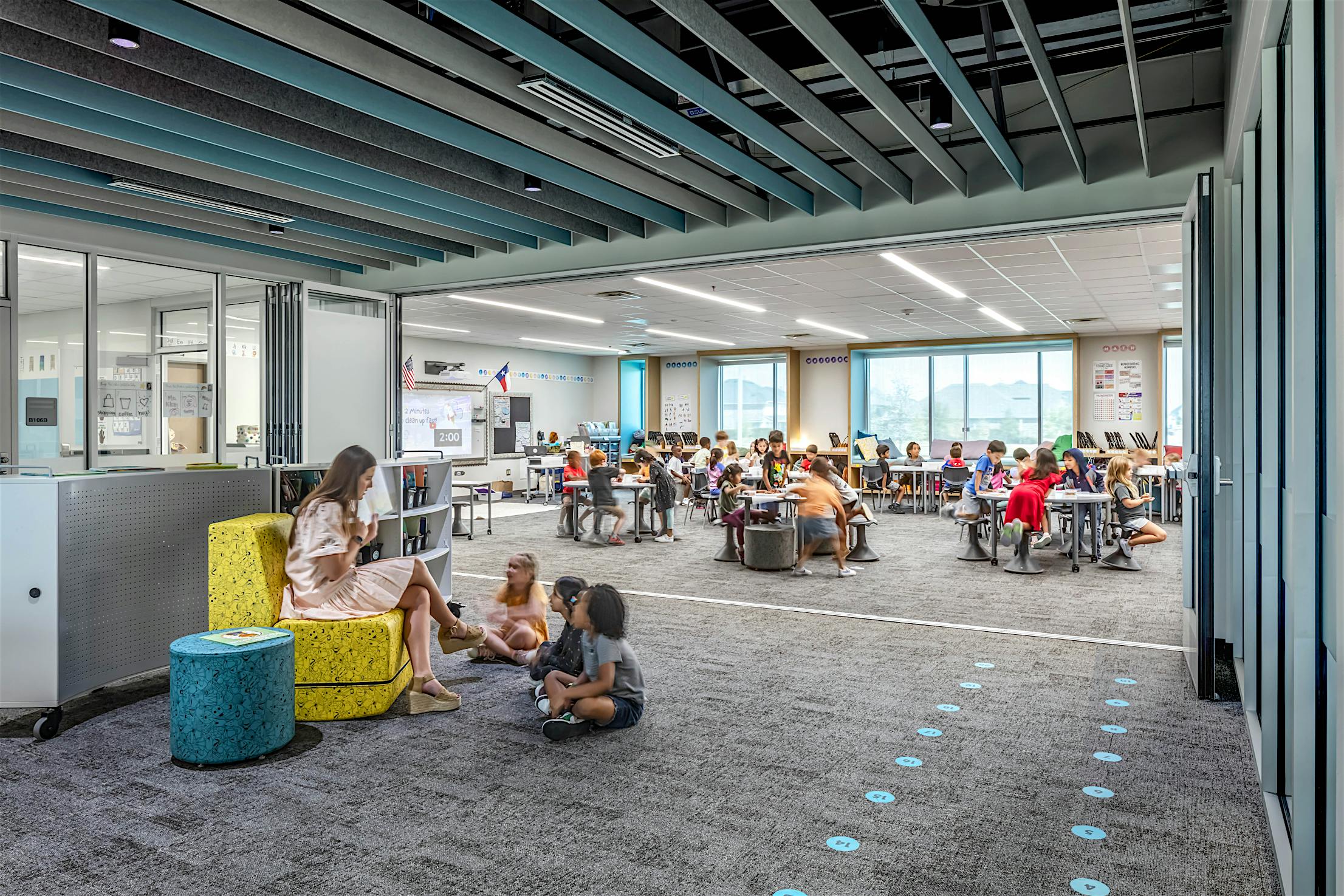 Modern classroom with acoustical commercial folding glass doors and bright lighting, creating an ideal education environment.