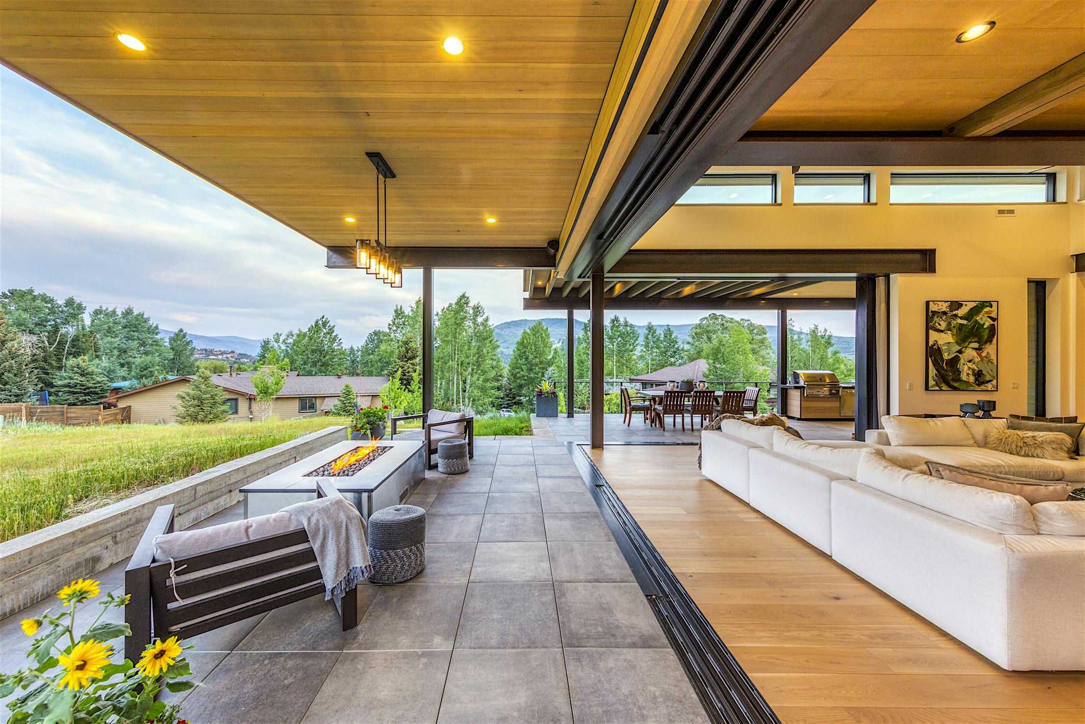 A modern home with a large deck and outdoor furniture