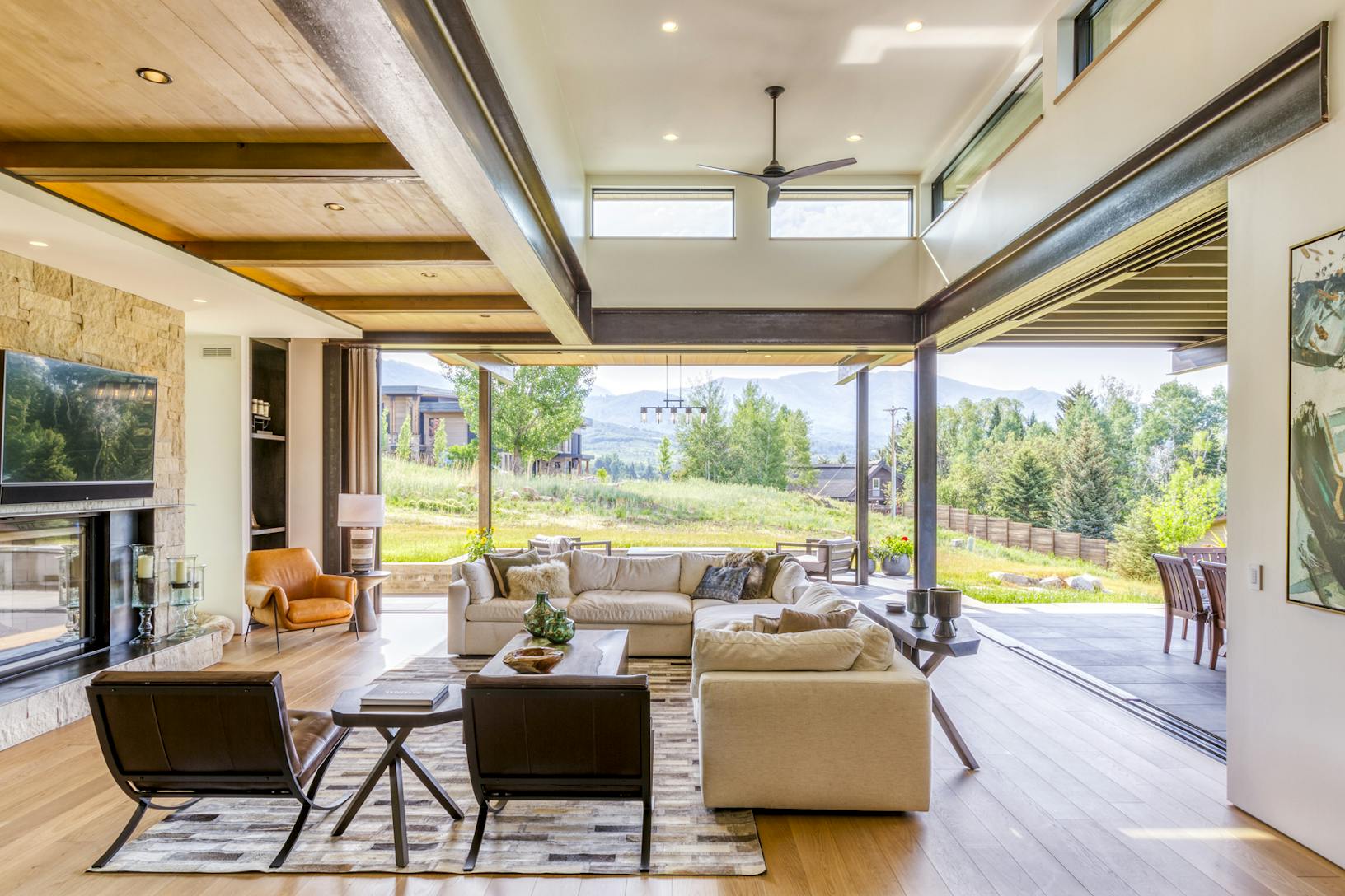 A living room with a fireplace and a view of the mountains- sliding doors