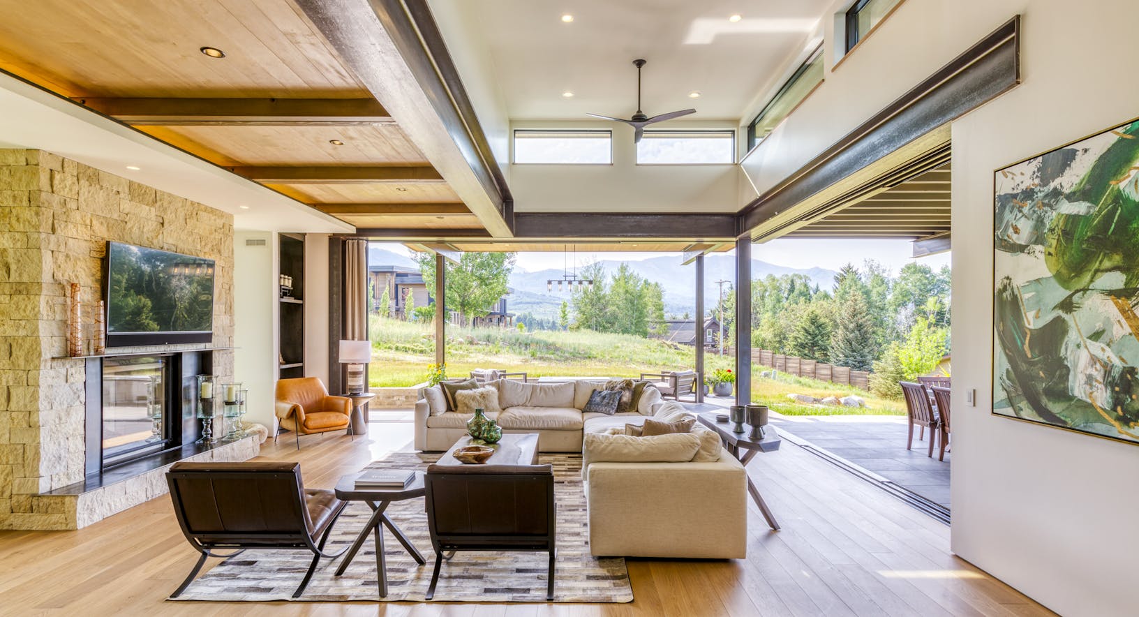 A living room with a fireplace and a view of the mountains- sliding doors