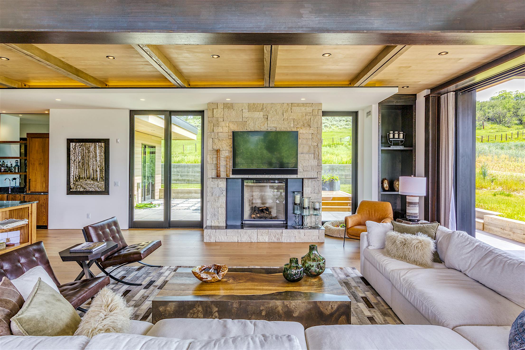 Modern living room with a fireplace and large panel sliding glass walls
