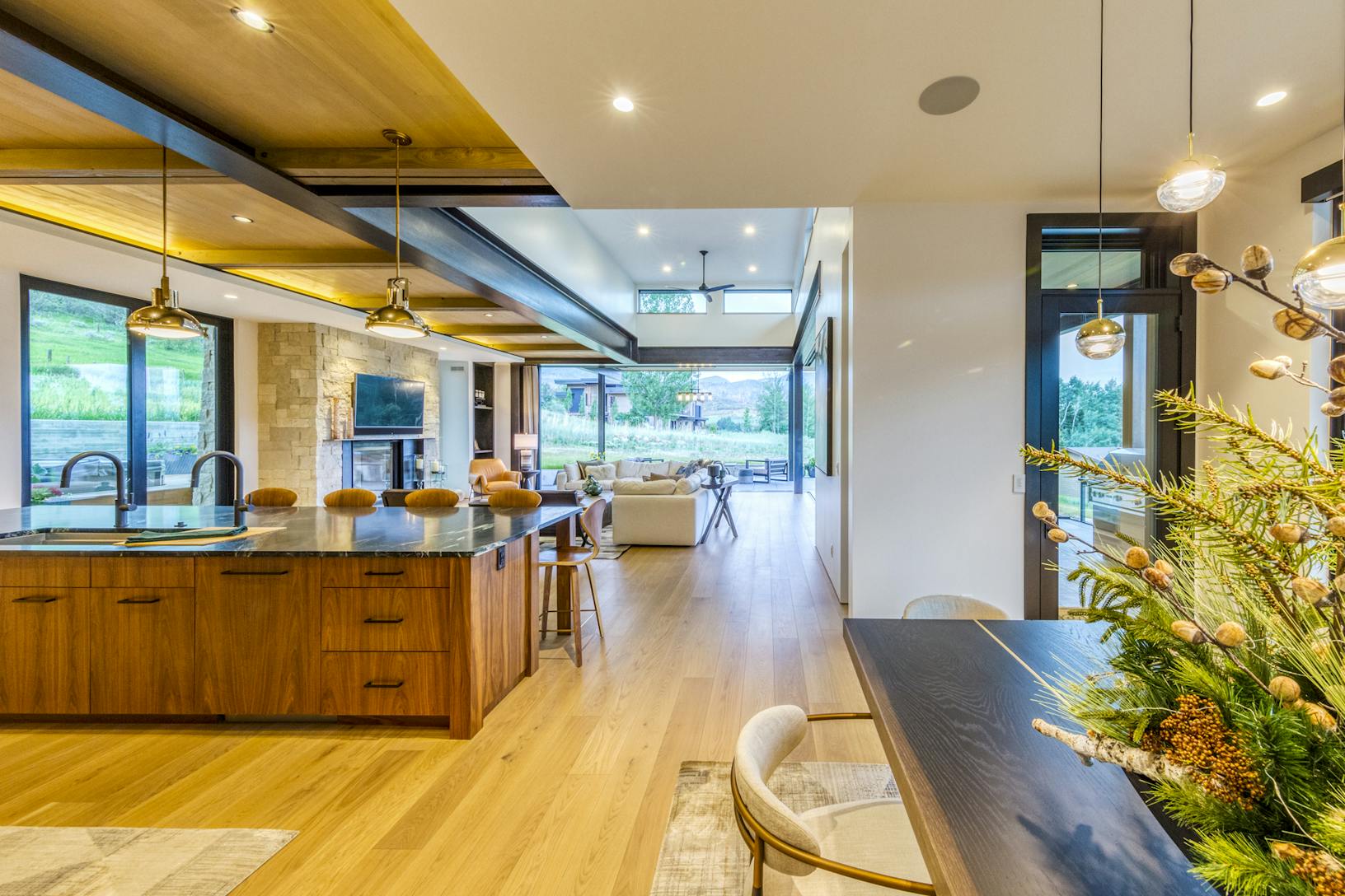 A modern kitchen with wood floors and a dining table- sliding doors
