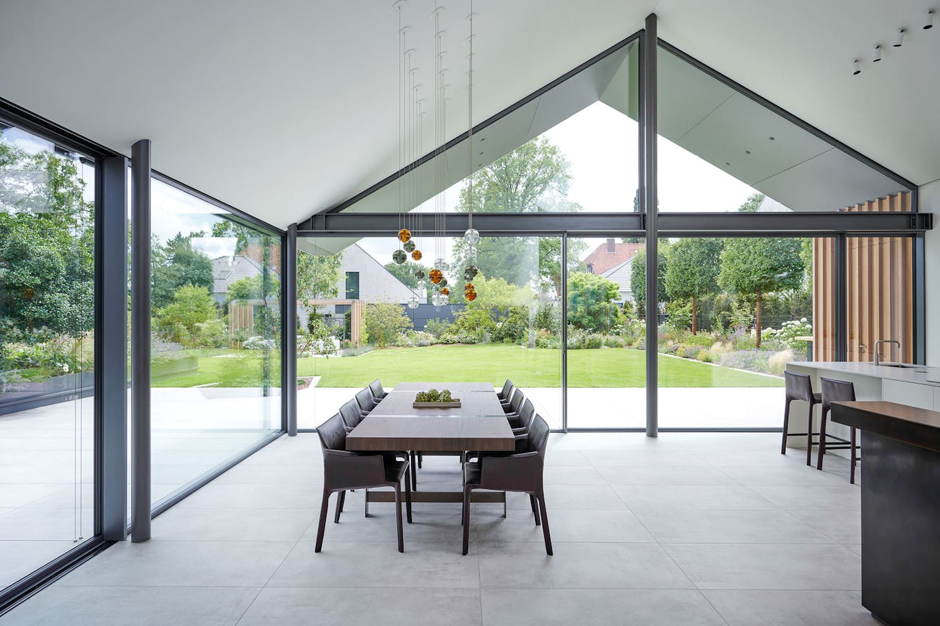 A modern dining room with glass walls and a dining table