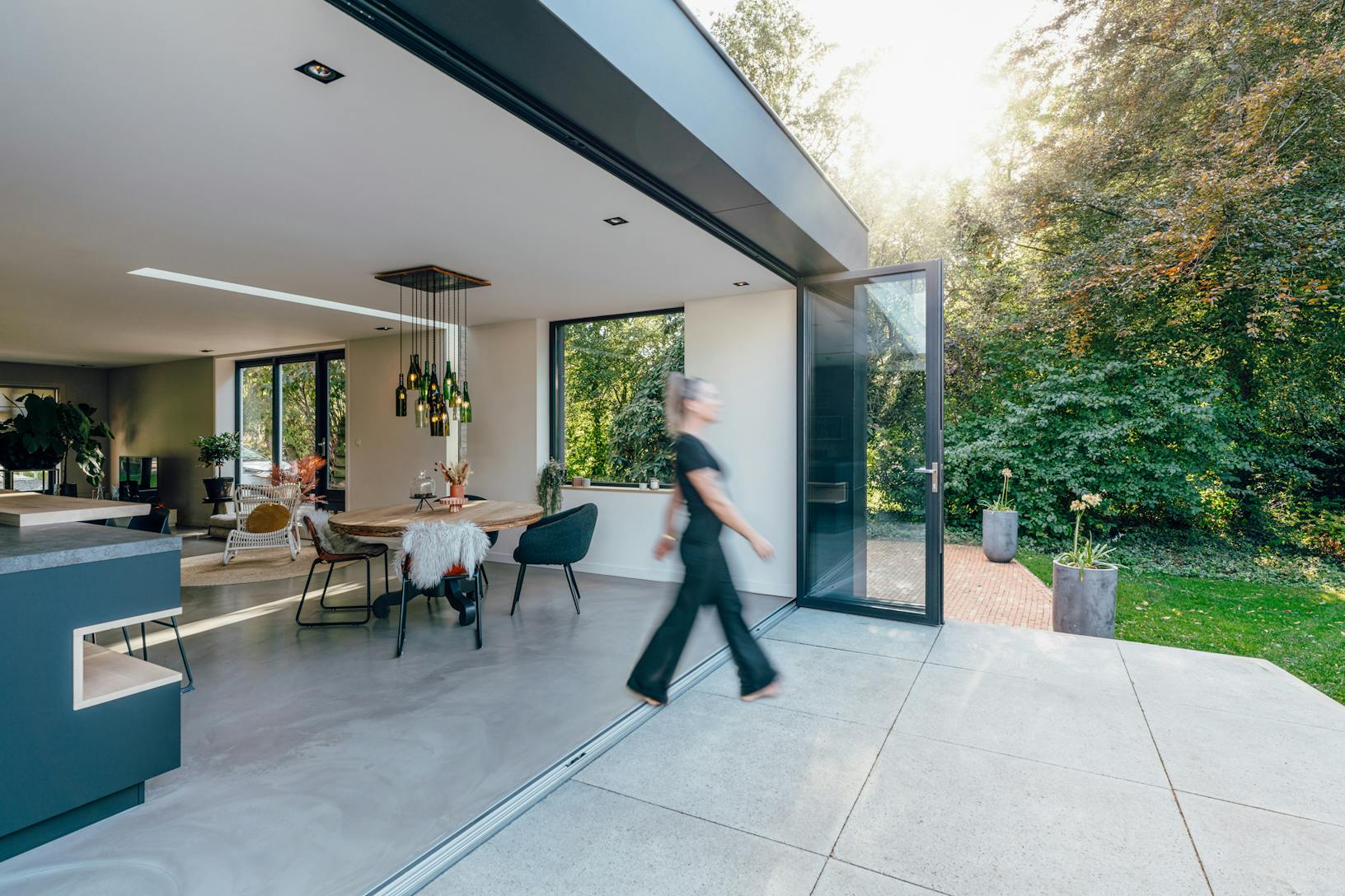 A woman walks through folding patio doors in a modern home