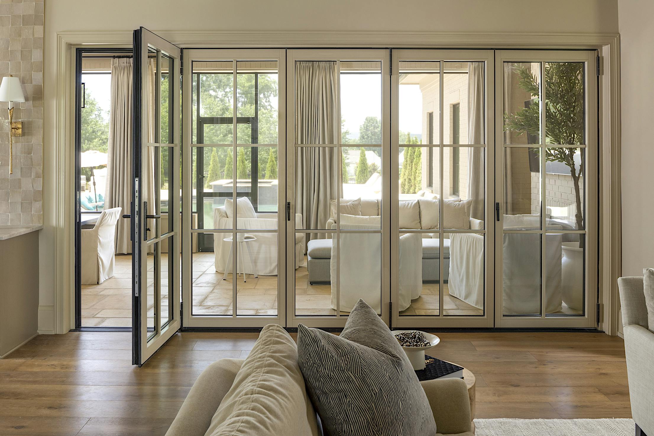 A living room with folding glass walls