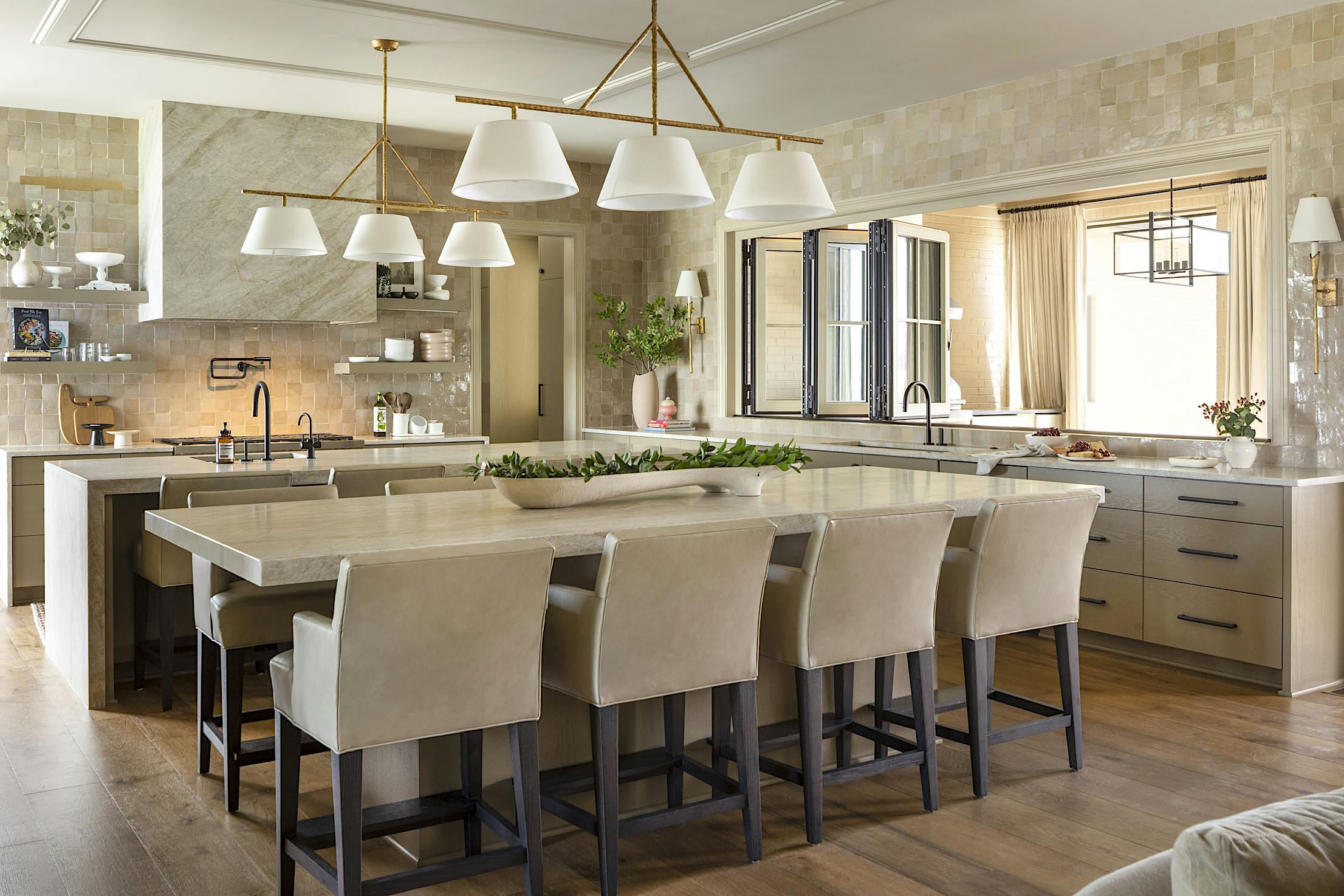 A spacious kitchen with a center island and folding glass windows